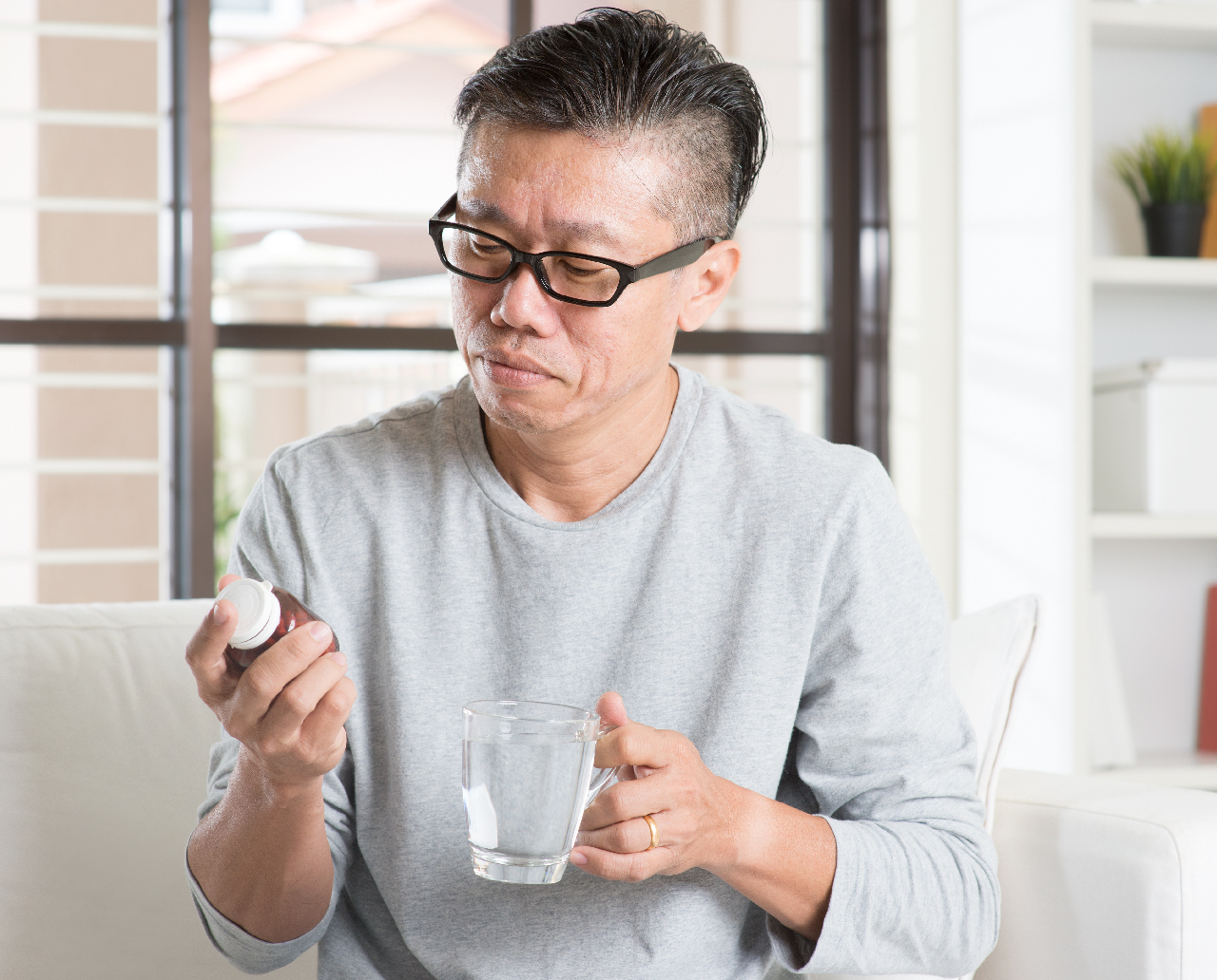 Patient at Home Looking at Pill Bottle